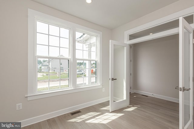 empty room featuring french doors and hardwood / wood-style flooring