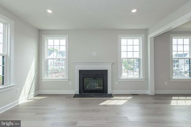 unfurnished living room with plenty of natural light and light wood-type flooring