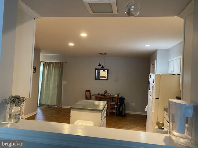 kitchen featuring baseboards, dark wood finished floors, recessed lighting, freestanding refrigerator, and white cabinets