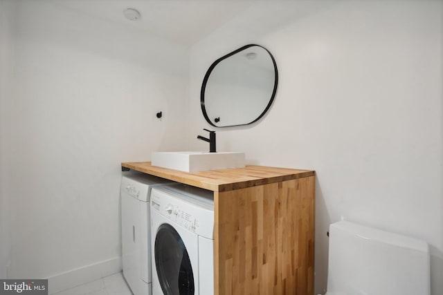 laundry room featuring tile flooring and sink