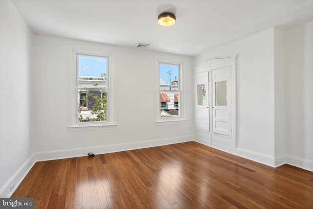 empty room with a healthy amount of sunlight and hardwood / wood-style flooring