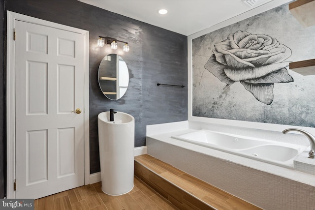 bathroom with a relaxing tiled bath