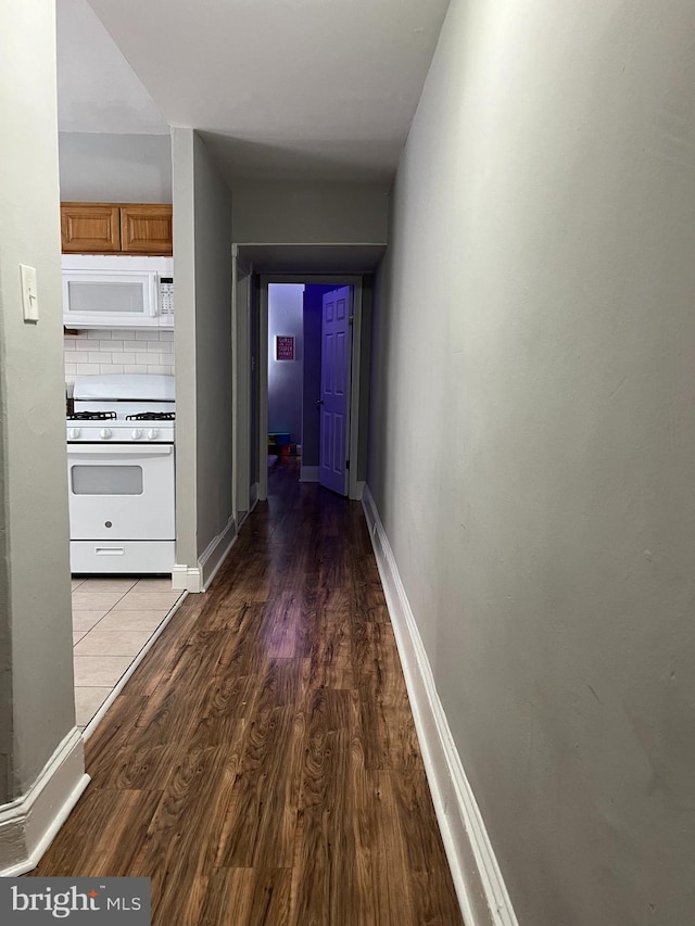 hallway with hardwood / wood-style floors