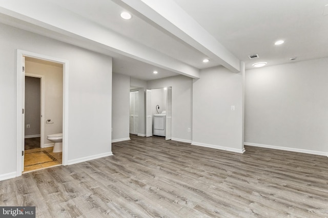 unfurnished living room with wood-type flooring and beamed ceiling