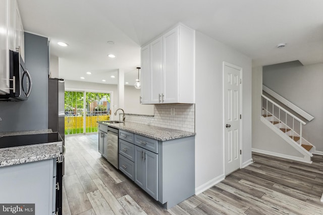 kitchen with gray cabinetry, appliances with stainless steel finishes, hardwood / wood-style flooring, white cabinets, and sink