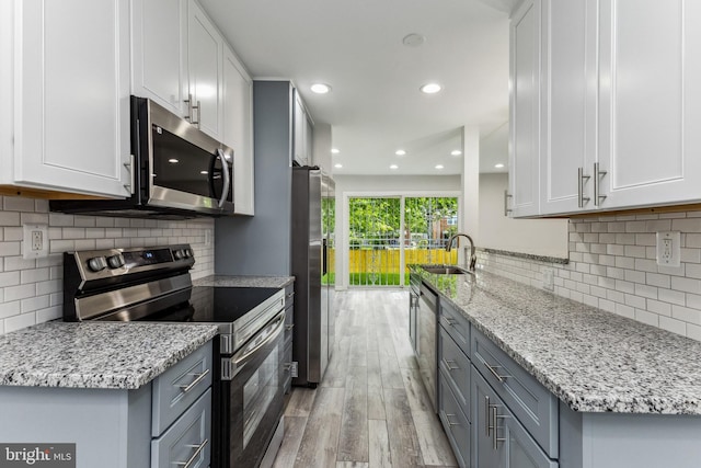 kitchen featuring gray cabinetry, stainless steel appliances, light hardwood / wood-style floors, and sink