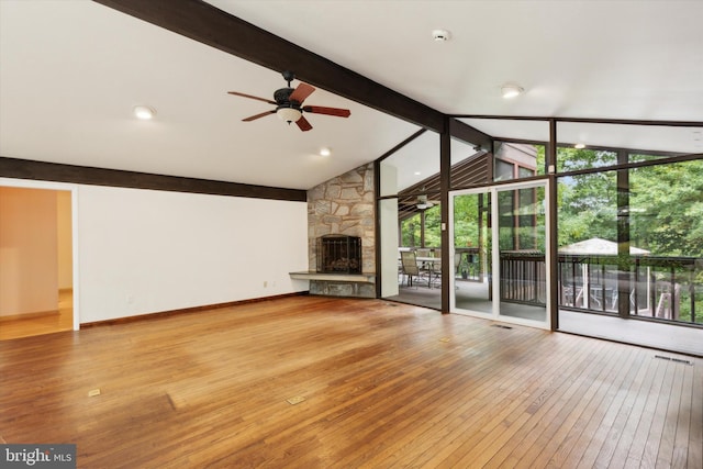 unfurnished living room featuring wood-type flooring, a fireplace, lofted ceiling with beams, and ceiling fan