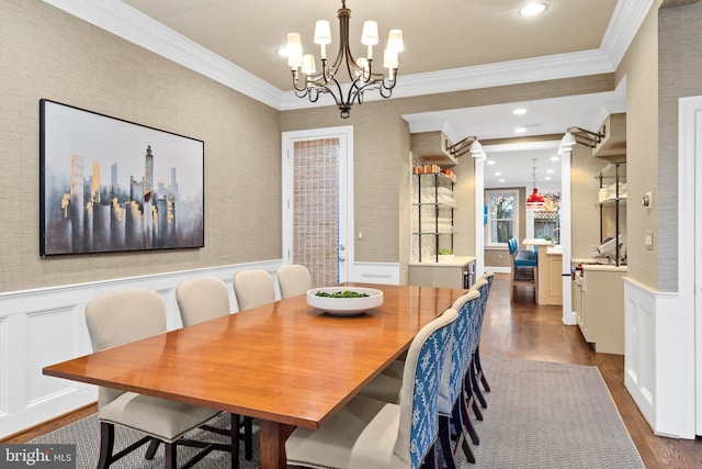 dining space with crown molding, dark hardwood / wood-style floors, and an inviting chandelier