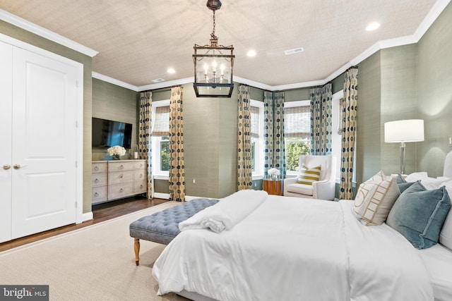 bedroom with crown molding, a chandelier, and hardwood / wood-style flooring