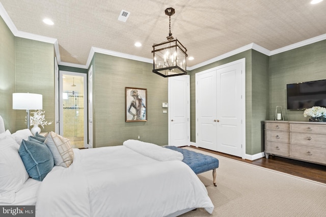 bedroom featuring a chandelier, a closet, dark hardwood / wood-style flooring, and crown molding