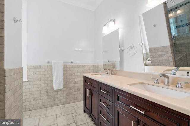 bathroom featuring vanity, a shower with shower door, and tile walls