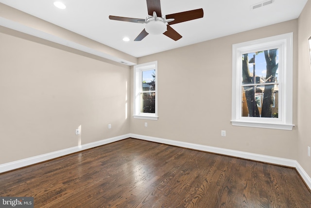 empty room with ceiling fan and dark hardwood / wood-style flooring