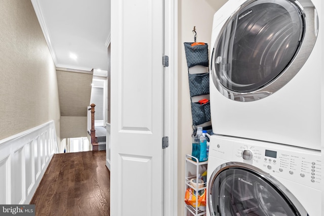 laundry area with hardwood / wood-style flooring, stacked washer / drying machine, and ornamental molding