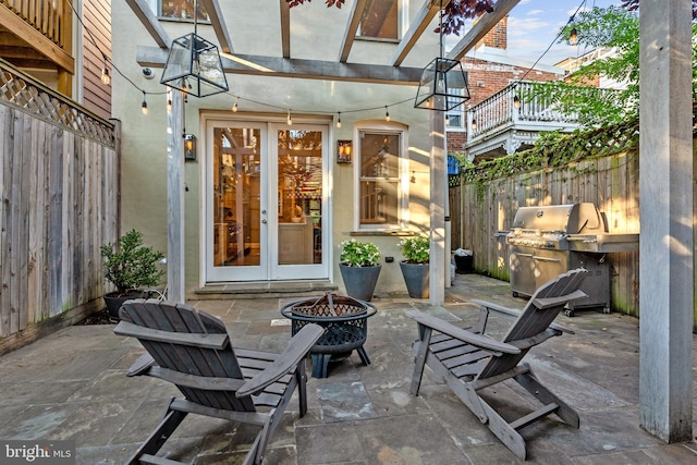 view of patio with a grill, an outdoor fire pit, and french doors