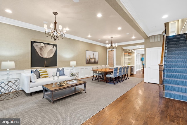 living room with a chandelier, hardwood / wood-style flooring, and crown molding