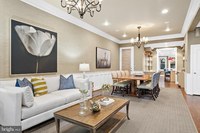 living room featuring wood-type flooring, crown molding, and a chandelier