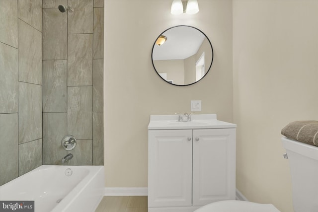 full bathroom with tile floors, vanity, tiled shower / bath combo, and toilet