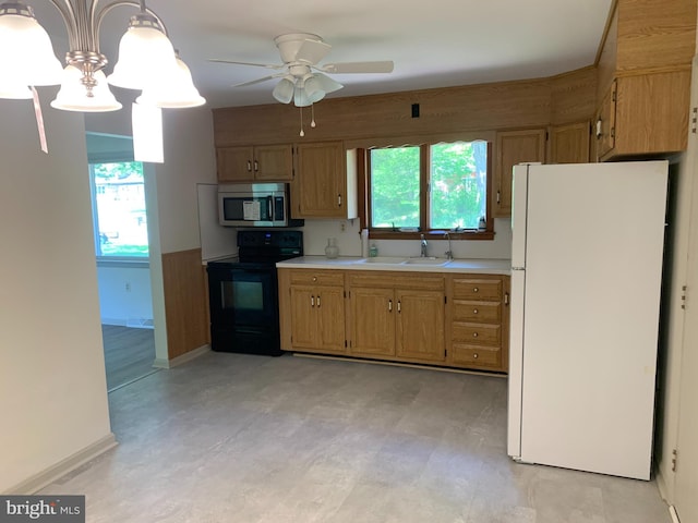 kitchen featuring hanging light fixtures, white refrigerator, electric range, sink, and ceiling fan