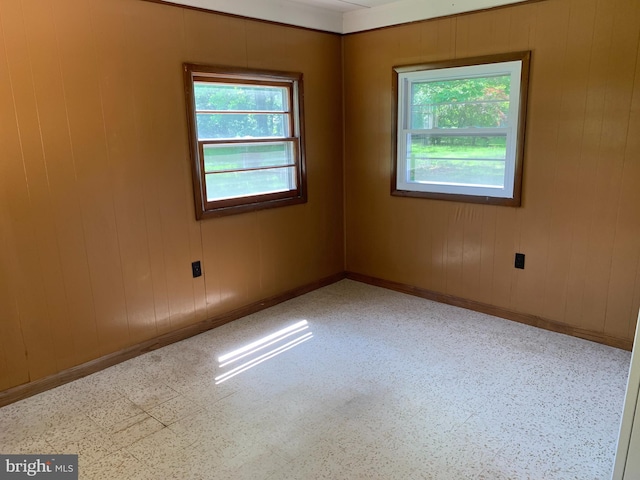 unfurnished room with wooden walls