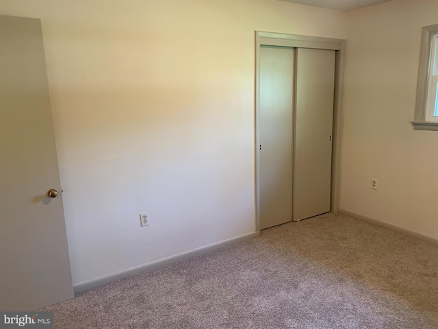 unfurnished bedroom featuring a closet and carpet flooring