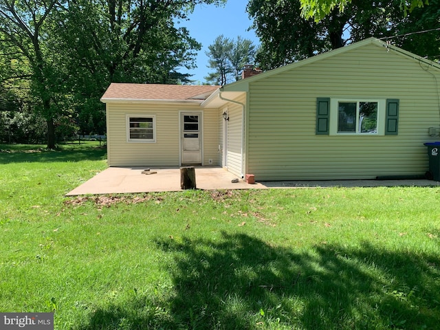 rear view of house with a lawn and a patio area