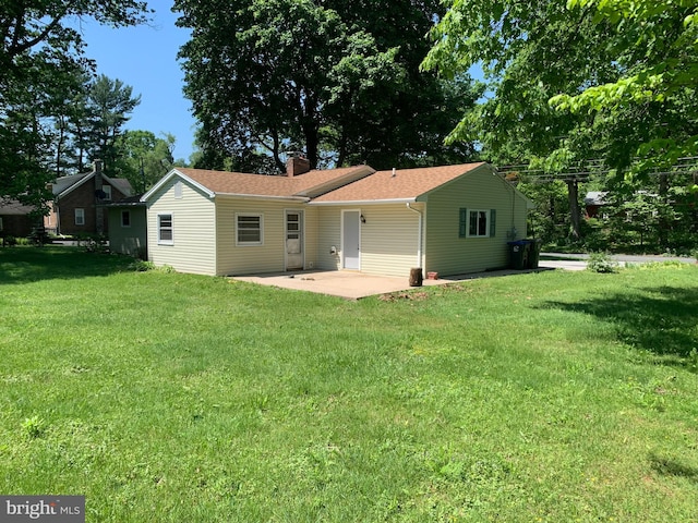 back of house with a patio and a yard