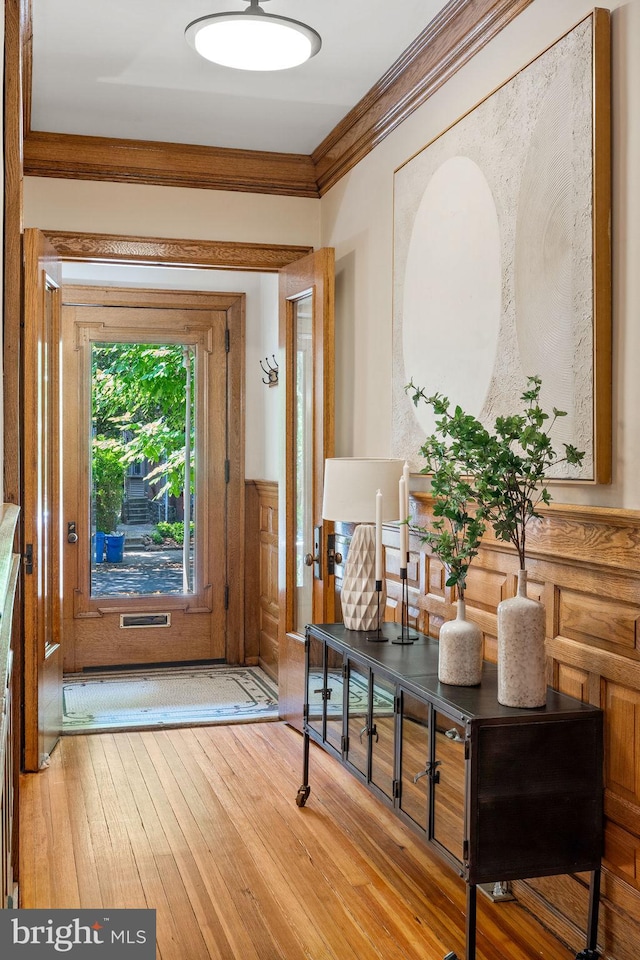 doorway to outside with crown molding and hardwood / wood-style floors