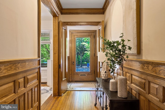 doorway to outside with light hardwood / wood-style flooring and ornamental molding