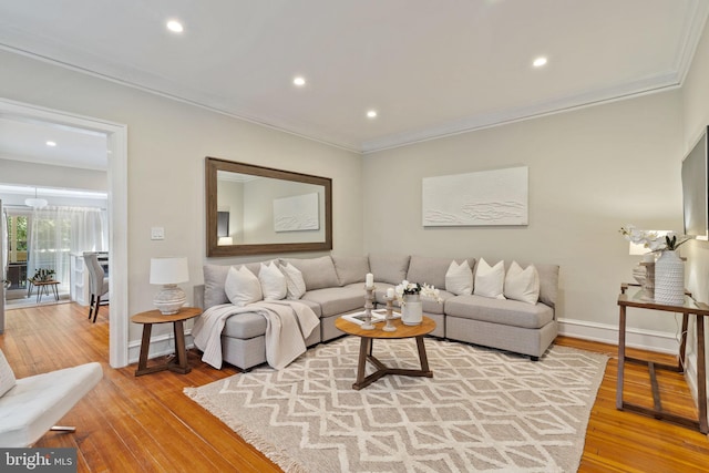 living room with crown molding and light wood-type flooring