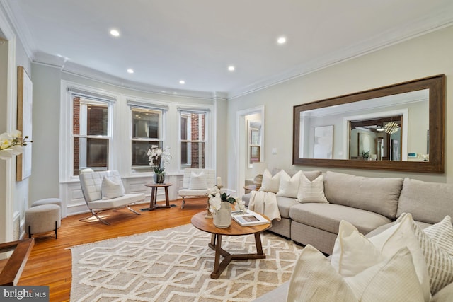 living room featuring light wood-type flooring and ornamental molding