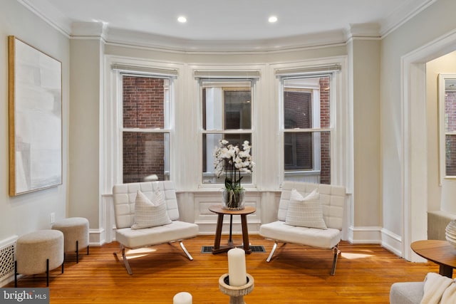 living area featuring light hardwood / wood-style floors and crown molding