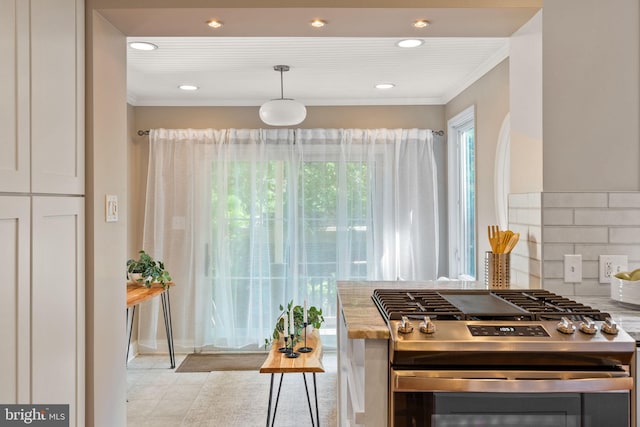 kitchen with white cabinetry, stainless steel gas range oven, crown molding, pendant lighting, and decorative backsplash