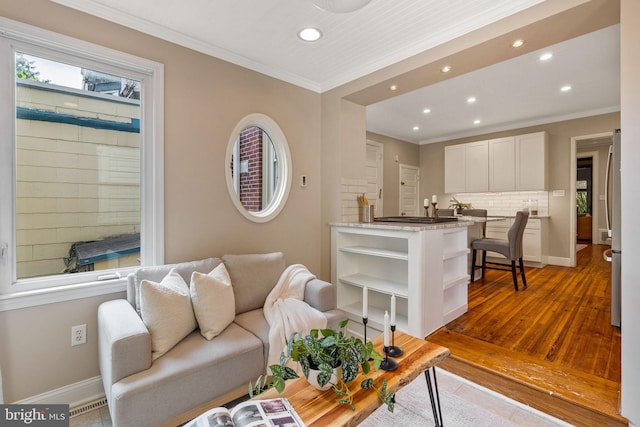 living room with crown molding and light hardwood / wood-style flooring