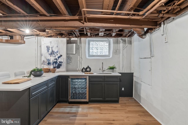 bar featuring light hardwood / wood-style floors, sink, and wine cooler