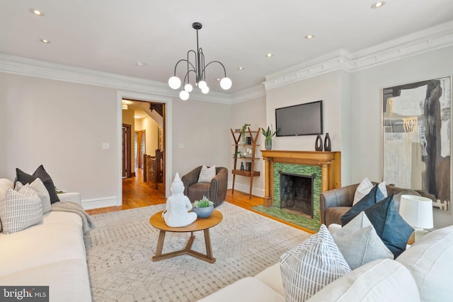 living room with a notable chandelier, light hardwood / wood-style floors, and crown molding