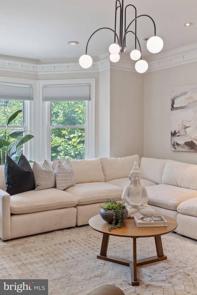 living room with crown molding and an inviting chandelier