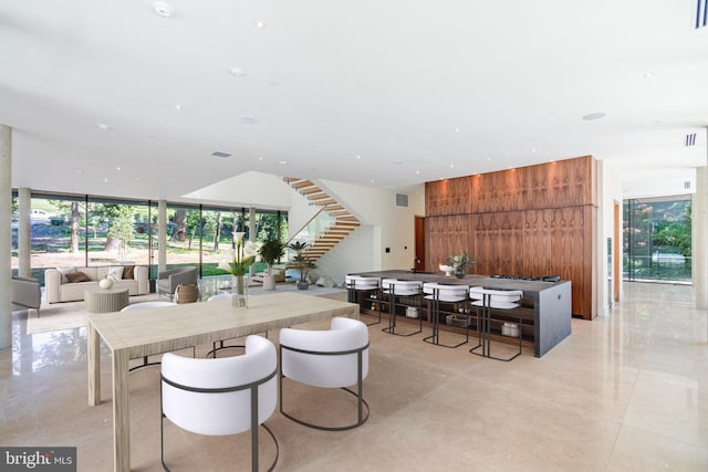 dining space with expansive windows and wood walls