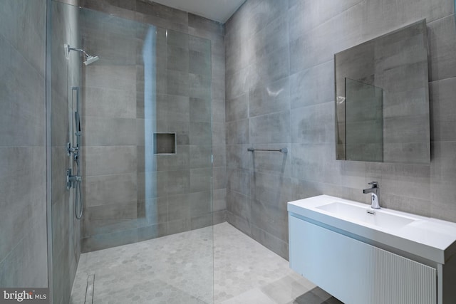 bathroom featuring a tile shower and vanity