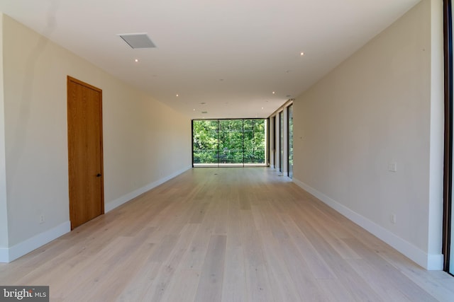 spare room with light wood-type flooring and floor to ceiling windows