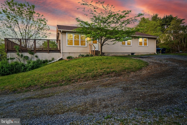 view of front of home with a deck and a lawn