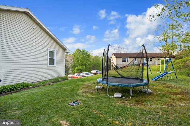 view of yard featuring a playground and a trampoline