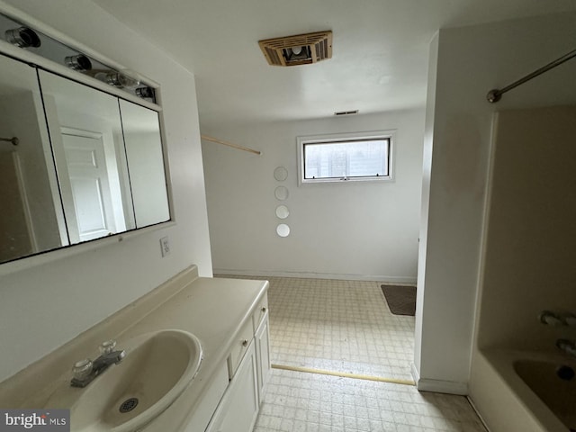 bathroom featuring vanity with extensive cabinet space, tile flooring, and shower / bathtub combination