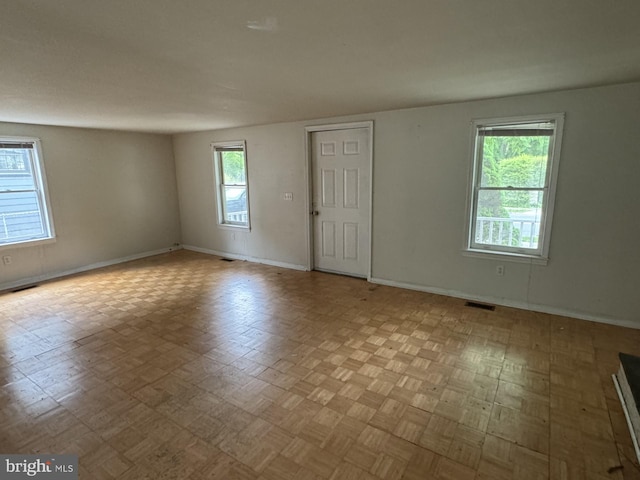 spare room with a wealth of natural light and parquet flooring