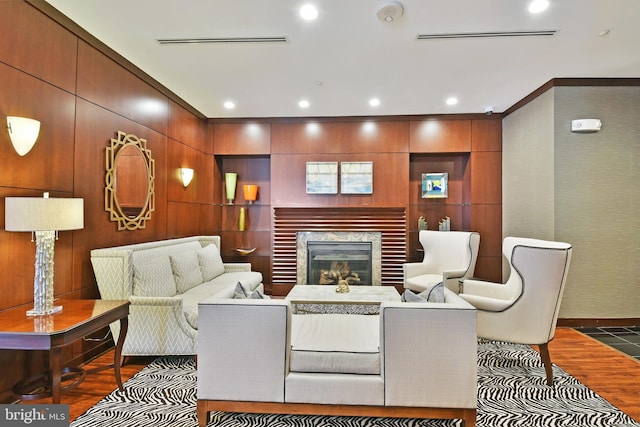 living room with dark wood-type flooring, a fireplace, and crown molding