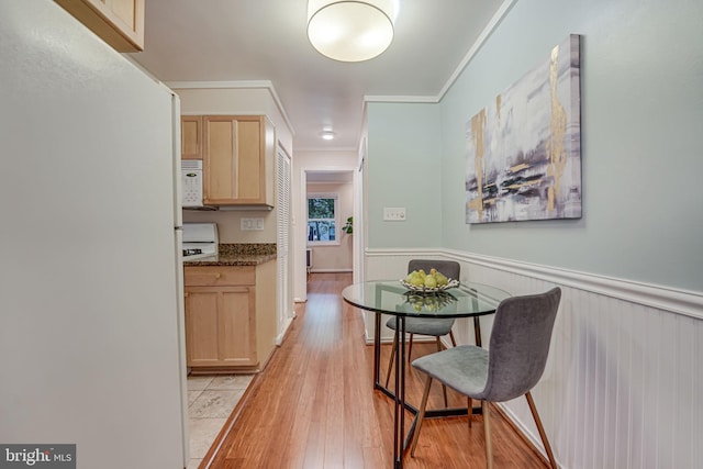 kitchen with light wood-type flooring, crown molding, and light brown cabinetry