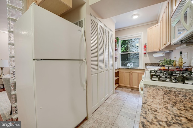 kitchen featuring light stone countertops, white appliances, and light brown cabinets