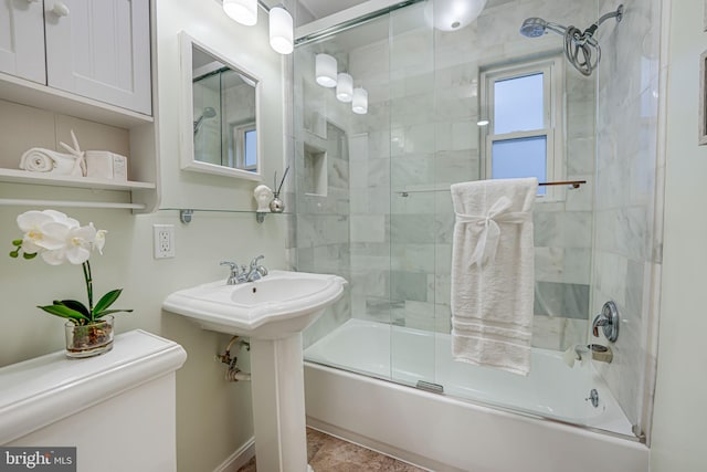 full bathroom featuring combined bath / shower with glass door, sink, and toilet