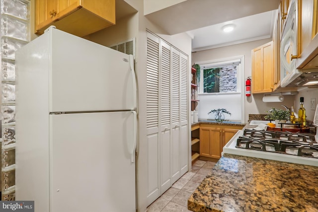 kitchen with white appliances, light brown cabinets, and light tile patterned floors