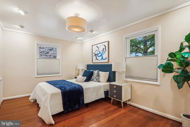 bedroom featuring crown molding and dark hardwood / wood-style flooring