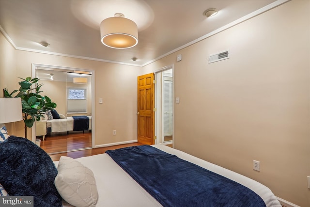 bedroom with ornamental molding, a closet, and hardwood / wood-style flooring